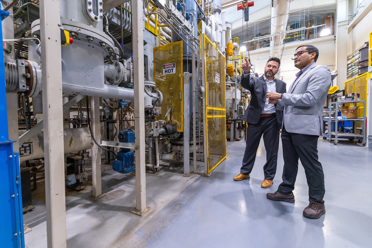 Kyle Anderson and Santanu Bakshi reviewing industrial research equipment.